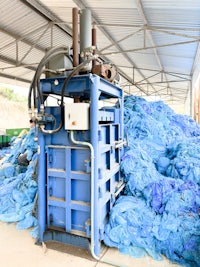 a machine is sitting in the middle of a pile of blue plastic bags