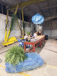 a group of people sitting at a table in a warehouse