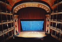 a stage in a theater with a blue curtain