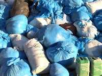 a pile of blue plastic bags on the ground