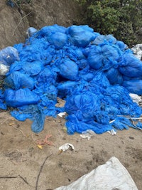 a pile of blue plastic bags on the ground