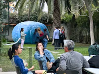 a group of people sitting around a table in a garden